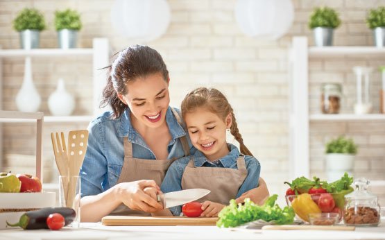 mae e filha a preparem legumes